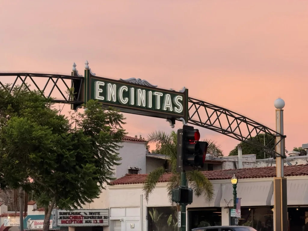 The Encinitas sign against a pink evening sky