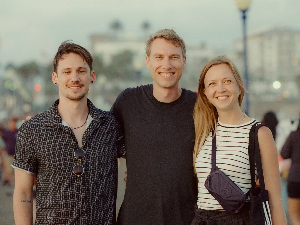 Three people smiling together outdoors